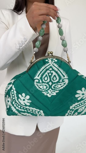Unrecognizable woman is holding stylish luxury green bag
