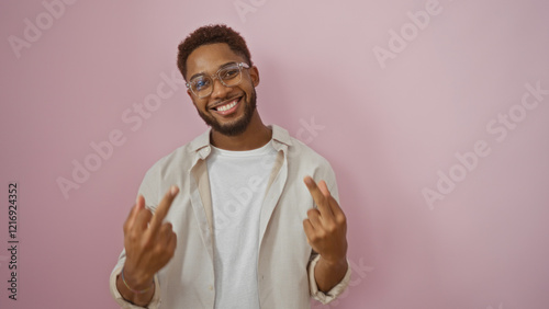 Young man wearing glasses making an obscene gesture with both middle fingers over an isolated pink background