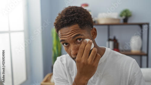 Handsome young man cleanses face at wellness spa center with a gentle expression