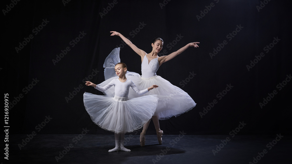 Naklejka premium Little kid and ballerina in white tutus gracefully perform synchronized arm movements, displaying elegance and poise against black background. Concept of ballet, elegance and beauty, grace. Ad