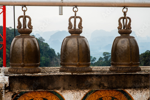 cloches de bronze sur fond de montagnes au Tiger Cave Temple, Krabi, Thaïlande photo