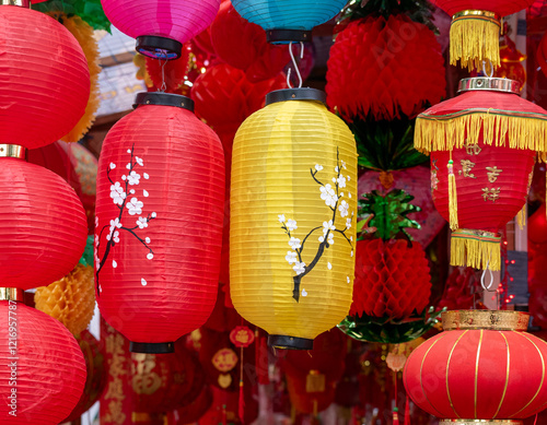 Colorful Chinese lanterns in various shapes and sizes, some with painted blossom branches. One lantern displays the character 