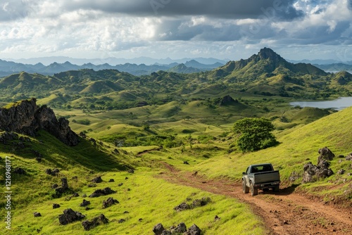 SUV drives scenic island dirt road, hills, clouds photo