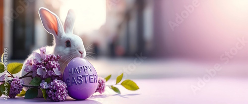 Easter bunny with  lilac and HAPPY EASTER egg inscription, on blurred street background, holiday greeting card. Copy space. photo