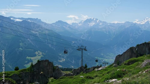 Cable car in Swiss Alps. Gondola from Grindelwald in Jungfrau. Summer Alpine landscape with snowcapped mountains background. Transport tourists uphill