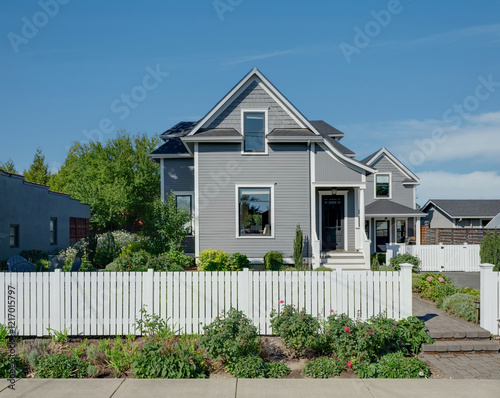A traditional cottage in Oregon nestled in lush landscapes with a white picket fence.