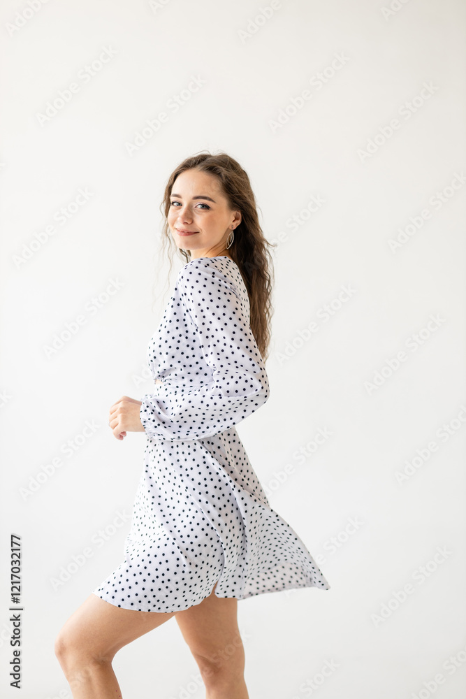 beautiful woman model posing in white polka dot dress in studio beautiful woman model posing in white polka dot dress in studio