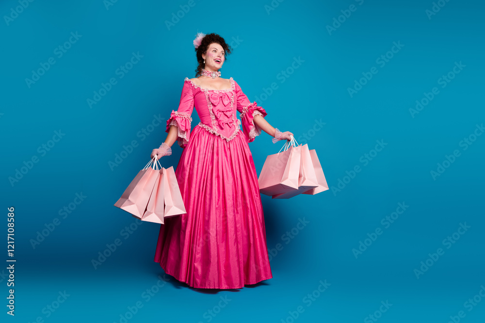 Elegant woman in a pink baroque gown holding shopping bags against vibrant blue background Elegant woman in a pink baroque gown holding shopping bags against vibrant blue background