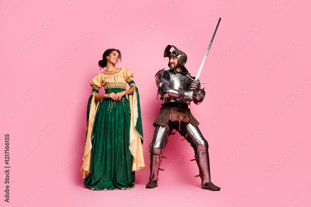 Naklejka premium Elegant couple in fantasy medieval costumes on pink studio background