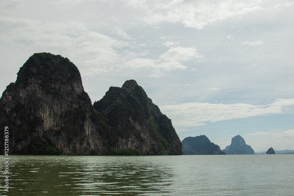 Naklejka premium Limestone cliffs rise dramatically above the emerald-green waters