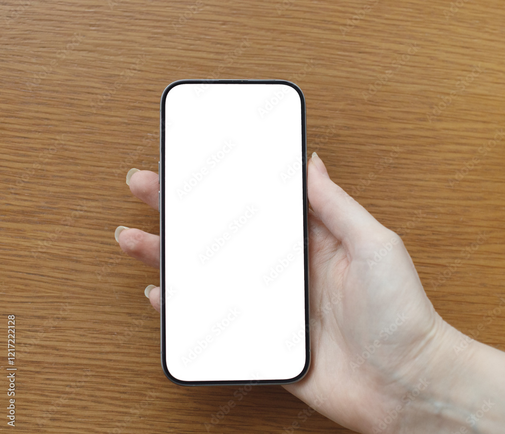 female hand holding modern smartphone with blank transparent background on wooden background
