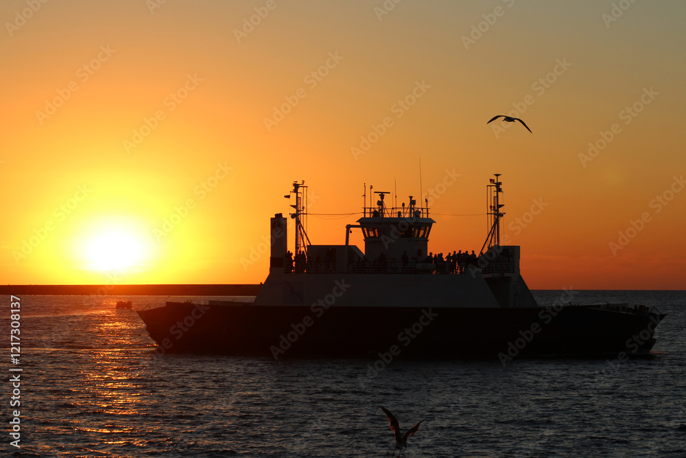 Fototapeta premium big ferry in the sea at sunset time