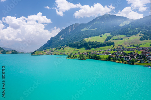 Aerial of Swiss village Lungern with traditional houses, old church Alter Kirchturm along lovely emerald green lake Lungerersee, canton of Obwalden Switzerland photo