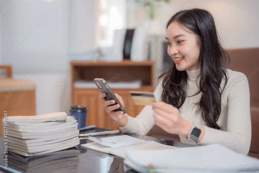 Young asian businesswoman sitting at her desk using smartphone and credit card for online shopping in modern office, online payment and e-commerce concept Young asian businesswoman sitting at her desk using smartphone and credit card for online shopping in modern office, online payment and e-commerce concept