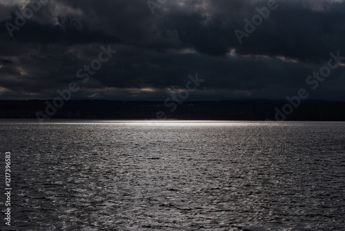 Schwarze Wolken über dem Wasser am Bodensee photo