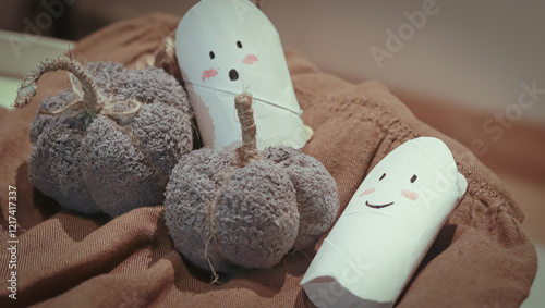 Handmade halloween pumpkin made of old wool sock and cute ghost decor made of toilet paper roll that shows a creative recycling DIY craft idea