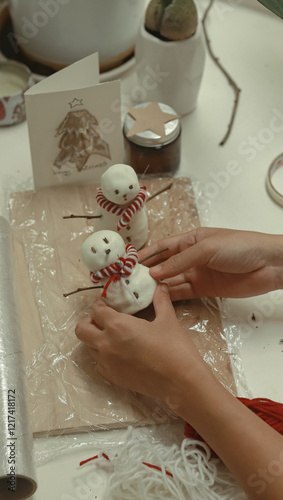 Hand molding DIY air dry clay made of glue and cornstarch into a snowman Christmas decor showing a sustainable eco-friendly way to celebrate the holiday season