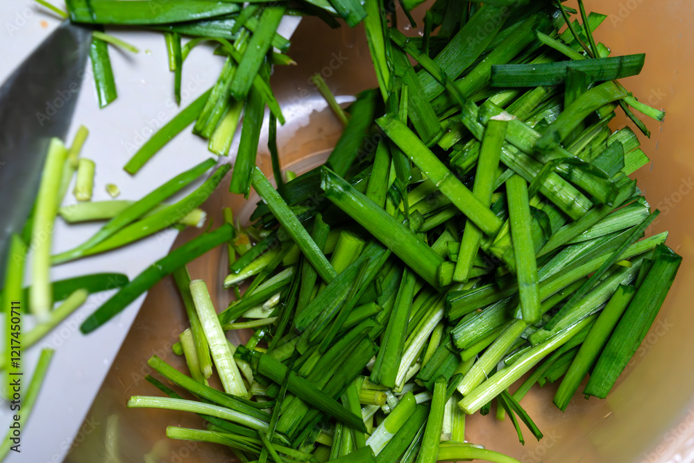 moving knife-cut chives from the cutting board to the bowl