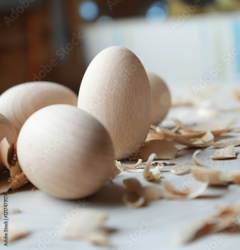 Close-up of wooden eggs with wood shavings on a light surface, highlighting natural textures, craftsmanship, and rustic aesthetics, perfect for themes of handmade crafts, woodworking, or minimal desig photo