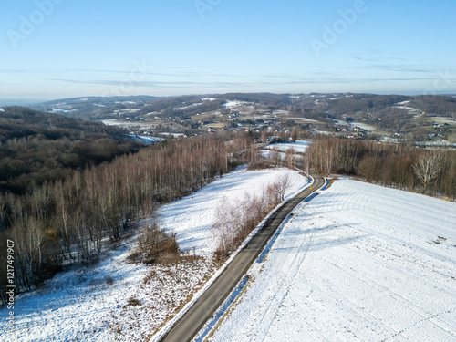 Foto A scenic aerial view of snow-covered fields and winding roads under a clear blue sky, showcasing the tranquility of winter landscapes