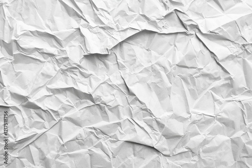 Crumpled white paper provides a textured background, suitable for various design and artistic applications, conveying a sense of imperfection or casualness