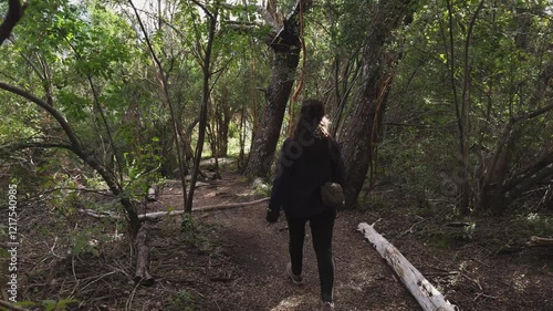 Woman walking in the forest in Los Alerces National Park, Patagonia, Argentina.