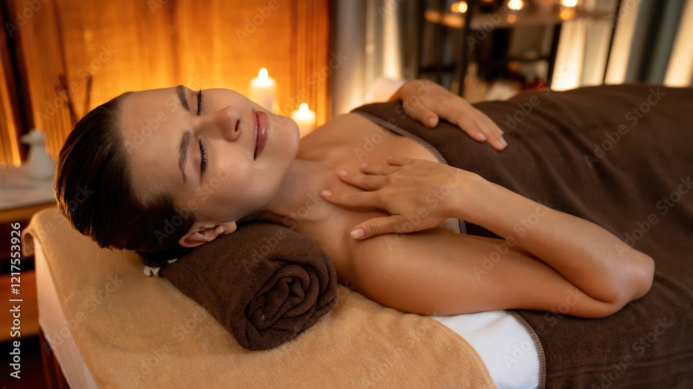 Fototapeta premium Caucasian woman customer enjoying relaxing anti-stress spa massage and pampering with beauty skin recreation leisure in warm candle lighting ambient salon spa at luxury resort or hotel. Quiescent
