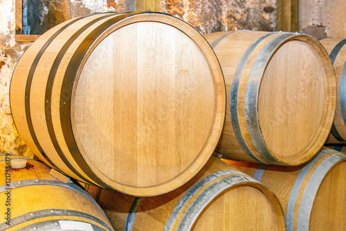 Wine barrels in the interior of cellar of winery. Wooden wine barrels in perspective. Vintage oak barrels in wine vaults. Barrels used in the process of making wine.