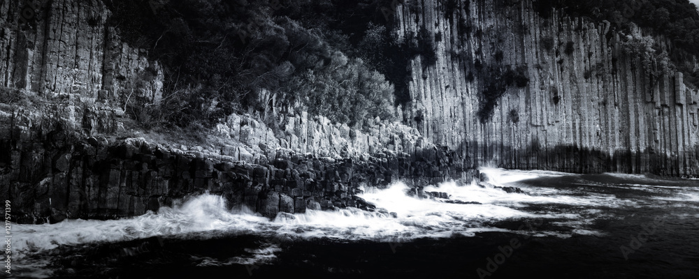 Naklejka premium Black and white seascape photo. Basalt cliffs by the sea.