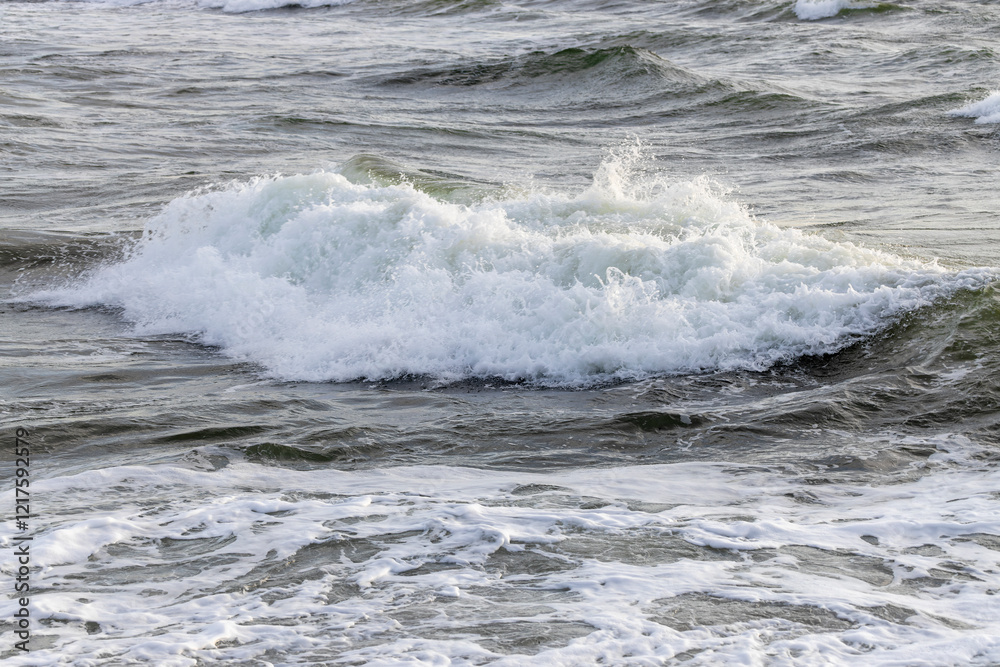 Fototapeta premium Breaking Ocean Waves at Seaside Shore with White Foam and Spray - Concept of Power, Force, Change, Washing Away, Fleeting Life Experience