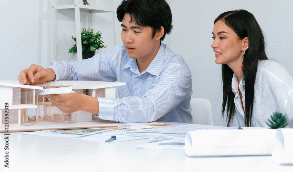 Fototapeta premium Portrait of cooperative engineer team working together to measure house model by using ruler and architectural equipment. Creative business design and teamwork concept. Immaculate..