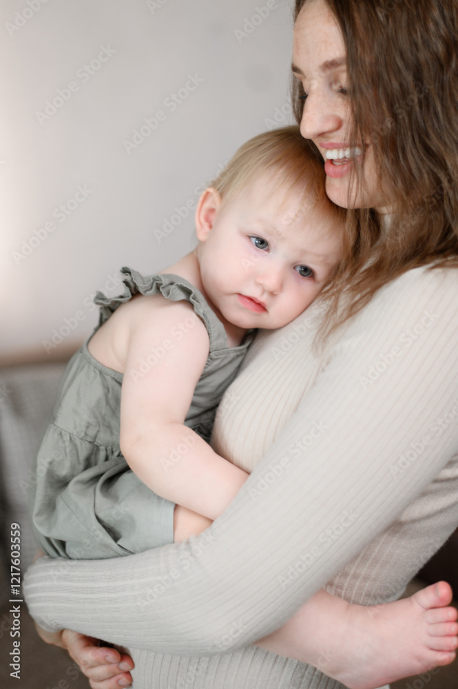 Happy mother holds toddler baby in her arms, he gently cuddles up to mother, feeling warmth and care. Motherhood concept, childhood, motherly care. Vertical Happy mother holds toddler baby in her arms, he gently cuddles up to mother, feeling warmth and care. Motherhood concept, childhood, motherly care. Vertical