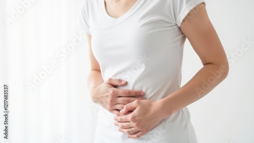 Wallpaper Mural Cropped shot of a young woman in a white t-shirt holding her side with her hands on a white background Torontodigital.ca