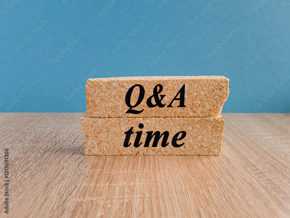 Q and A, questions and answers time symbol. Concept words 'Q and A time' on brick blocks on a wooden table, beautiful black background. Business and Q and A time concept.