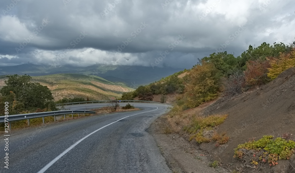 Russia, Republic of Crimea. View of the winding paved road along the Black Sea coast near the town of Sudak surrounded by picturesque mountains.