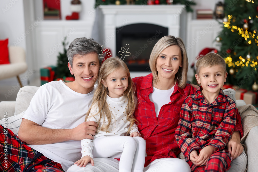 Happy family in pajamas on sofa at home. Christmas morning Happy family in pajamas on sofa at home. Christmas morning