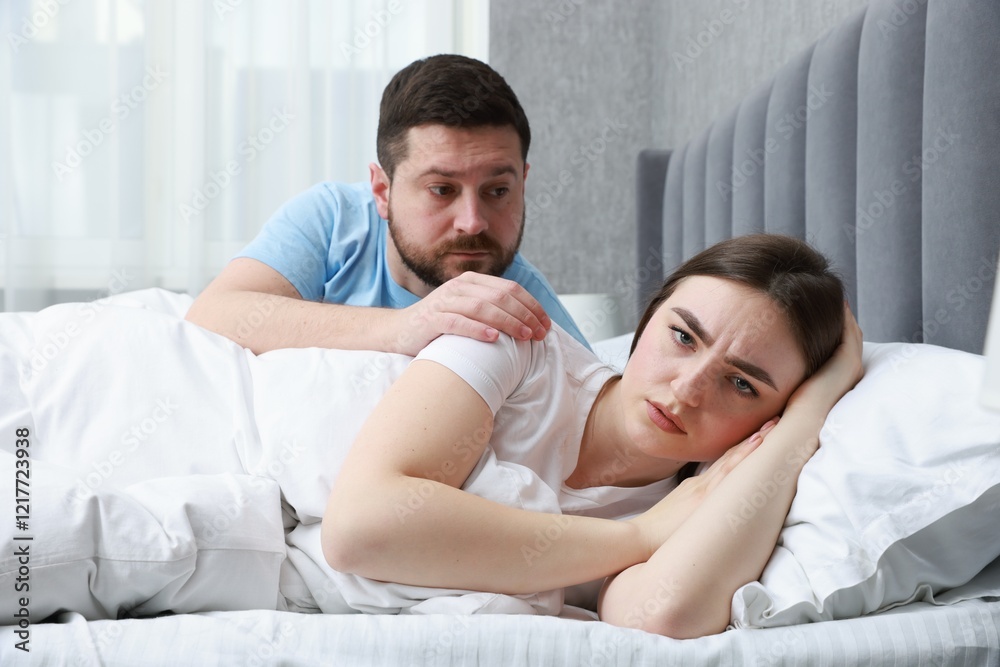 Man comforting his resentful girlfriend on bed at home Man comforting his resentful girlfriend on bed at home