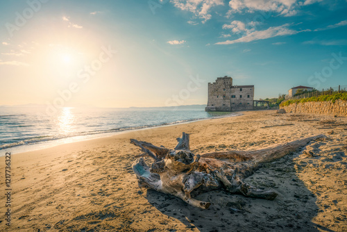Fototapeta Naklejka Na Ścianę i Meble -  Torre Mozza beach and a trunk with an old building on the sea. Follonica, Italy
