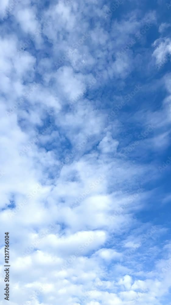 White ragged cloudscape spreading by the blue summer sky. Formation of rain clouds in the atmosphere. Vertical video. White ragged cloudscape spreading by the blue summer sky. Formation of rain clouds in the atmosphere. Vertical video.