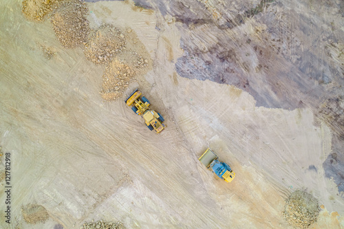 zenithal photograph of a bulldozer and a steamroller on a construction site, aerial view with drone