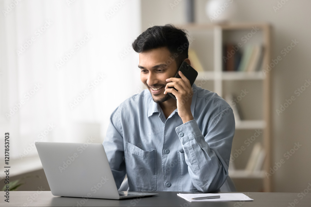 Consultation on distance. Modern day young male worker freelancer consult support client by phone from remote workplace talk to customer looking on notebook screen discuss business details with smile Consultation on distance. Modern day young male worker freelancer consult support client by phone from remote workplace talk to customer looking on notebook screen discuss business details with smile
