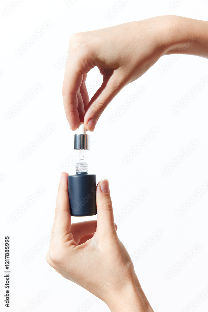 Two hands holding a small bottle with a cap on top Two hands holding a small bottle with a cap on top