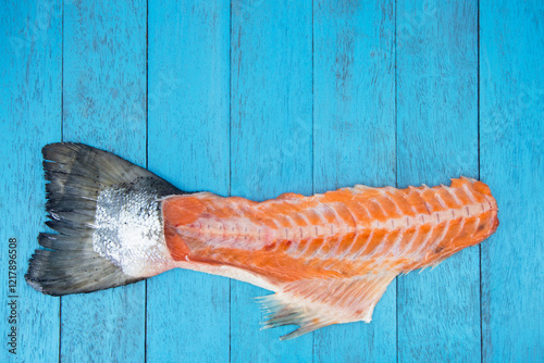 Schilderij op canvas Filleted raw salmon carcass on a blue wooden background