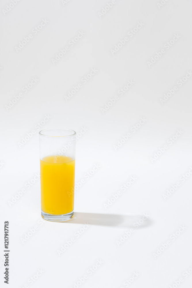 single glass of fresh orange juice placed on a pristine white background, creating a minimalist and clean aesthetic. The vibrant orange color of the juice contrasts with the neutral tones single glass of fresh orange juice placed on a pristine white background, creating a minimalist and clean aesthetic. The vibrant orange color of the juice contrasts with the neutral tones