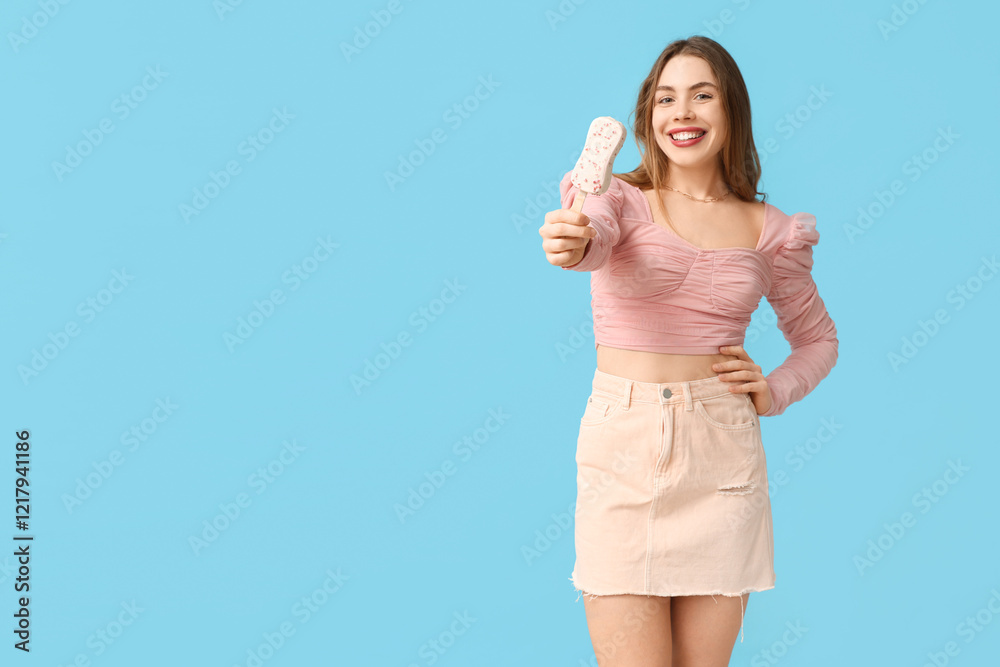 Happy smiling young woman holding white chocolate covered ice cream with strawberry on blue background Happy smiling young woman holding white chocolate covered ice cream with strawberry on blue background