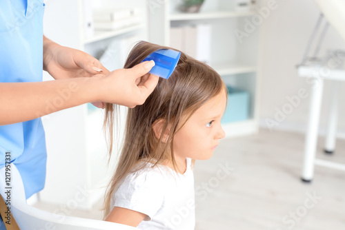 Female doctor combing littl...