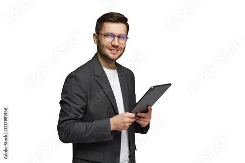 Young man in a suit smiling while holding a tablet in a bright setting