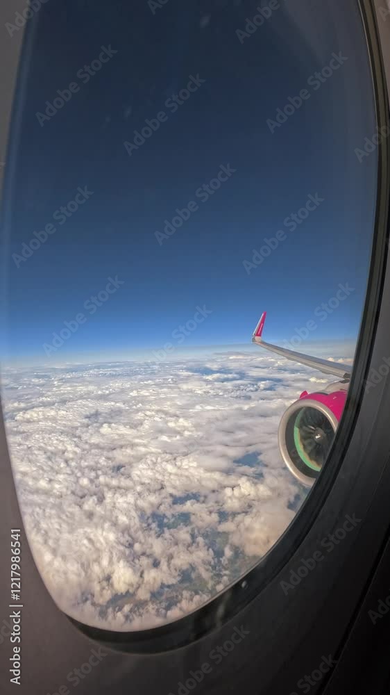Engine view of an airplane flying above the clouds with sunset sky. View from the plane window 