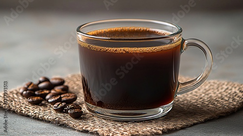 Dark coffee in glass mug on burlap.