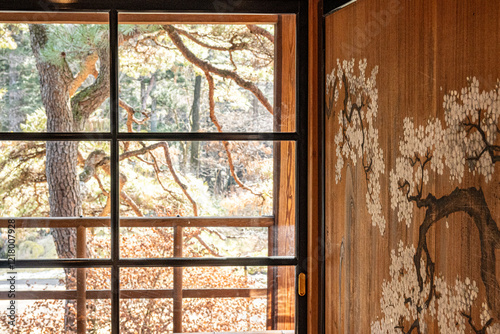 Japandi interior, a room with Japanese paintings on the wall with earthy brown tones and sunlight shining through the windows inside the Tamozawa Imperial Villa Memorial Park  Nikko Japan.